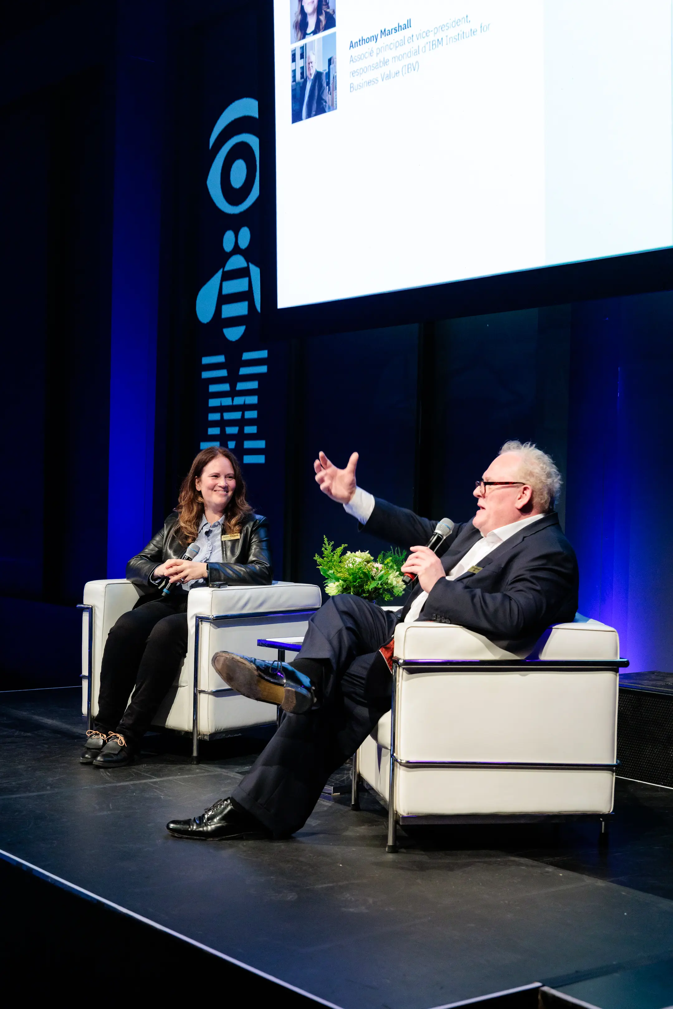 IBM — Two speakers in white armchairs on the stage, one gesturing