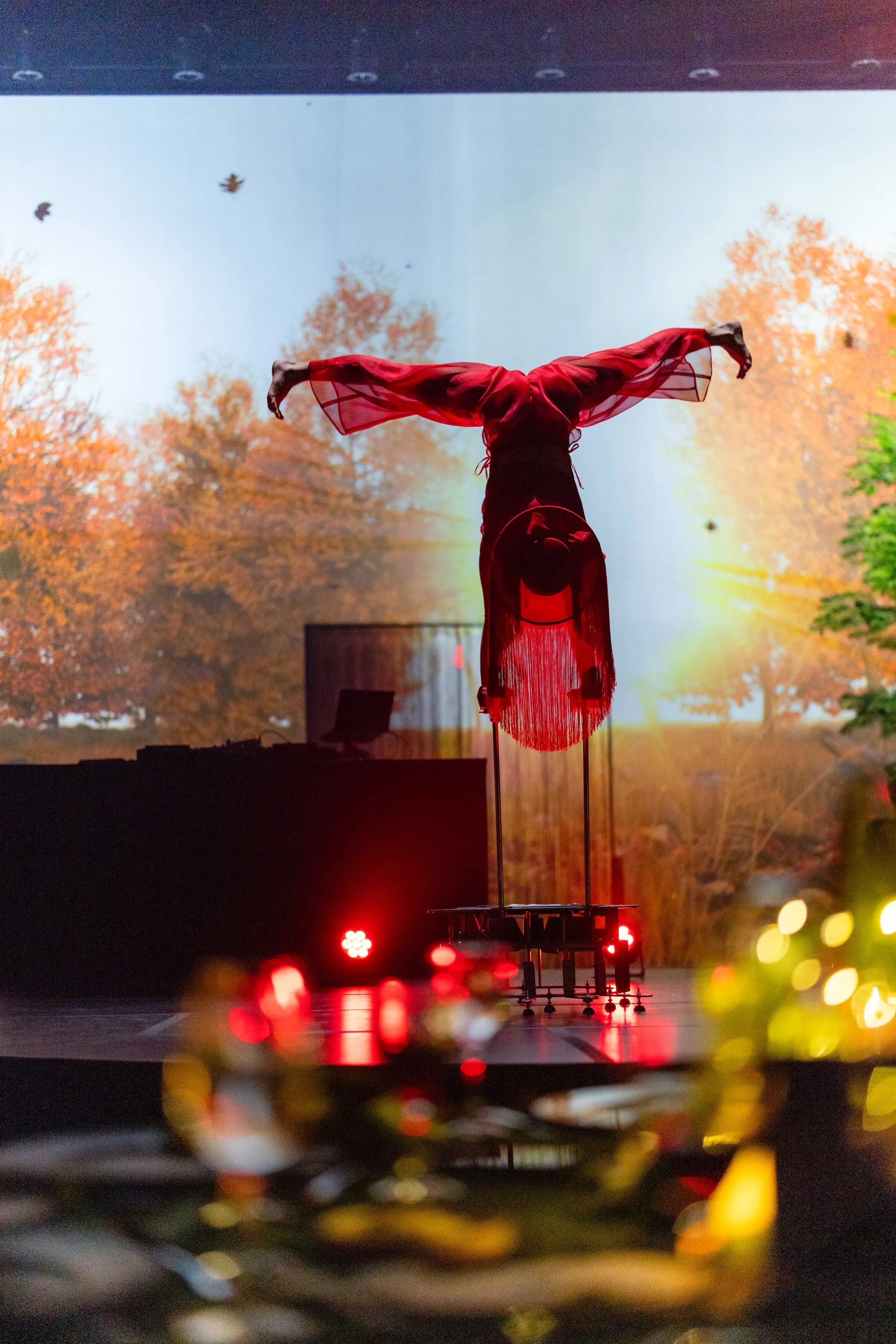 IBM — A performer in red above the autumn projection