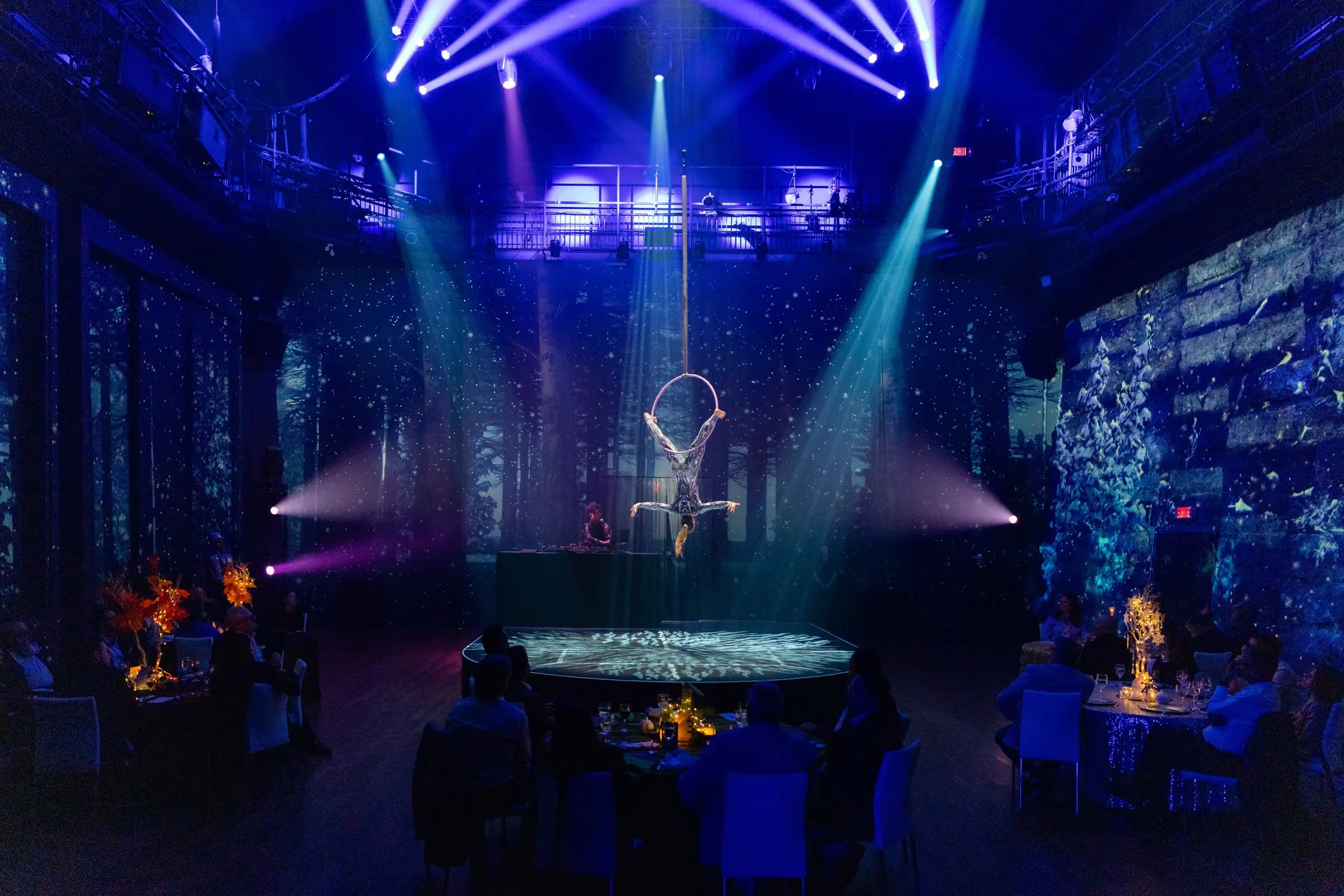 IBM — The full hall in blue light, an aerialist above the round stage